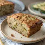 A single slice of moist gluten free zucchini banana bread on a plate.