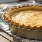 the prepared gluten-free pie crust dough disk being wrapped for its essential chilling period.