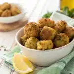 A close-up of a single Broccoli Tot broken open to show the cheesy green center.