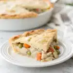 A single slice of gluten free chicken pot pie showcasing its flaky crust and creamy interior.