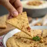 Slicing a baked Gluten Free Chickpea Flatbread into wedges.